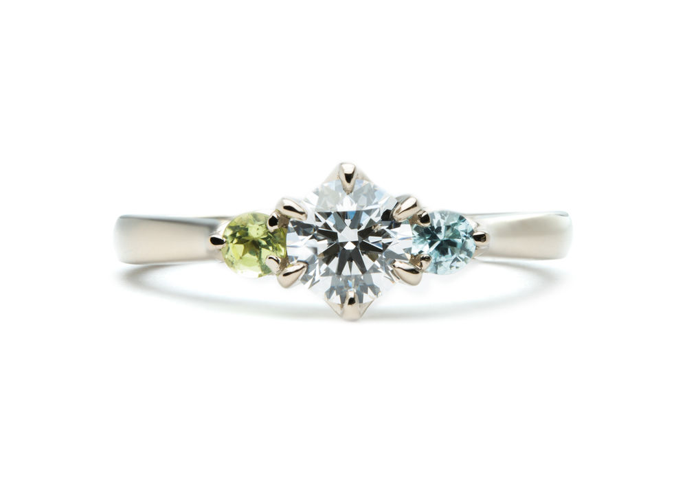 ペリドットとブルージルコンが留まったシャンパンゴールドの婚約指輪