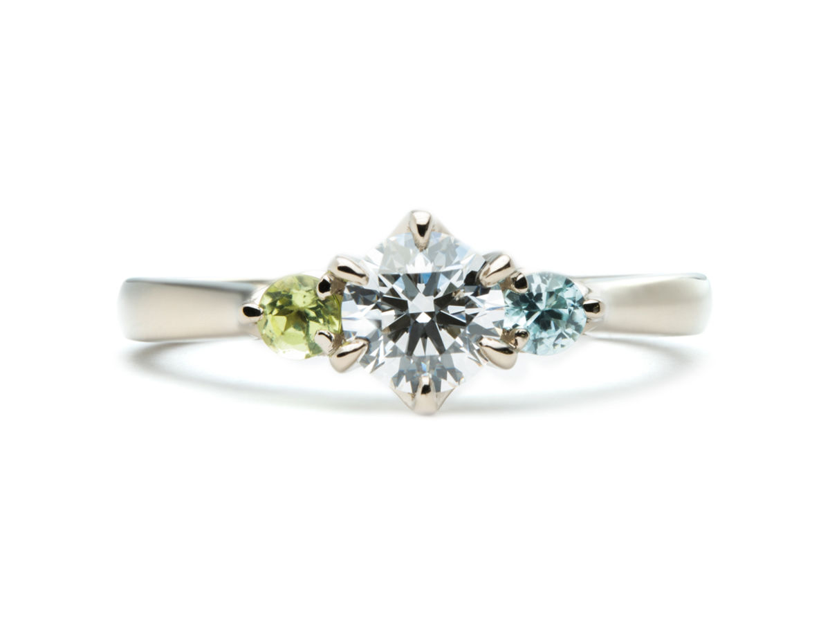 ペリドットとブルージルコンが留まったシャンパンゴールドの婚約指輪