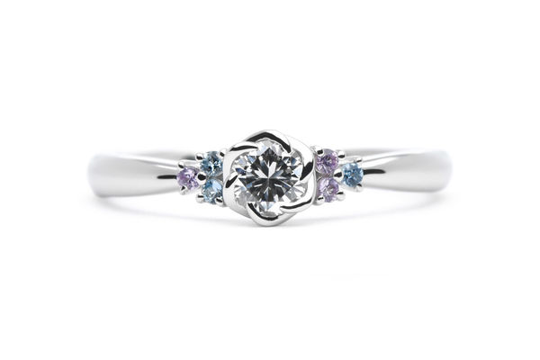 お花の爪のカラフルなサイドメレが留まった手作り婚約指輪