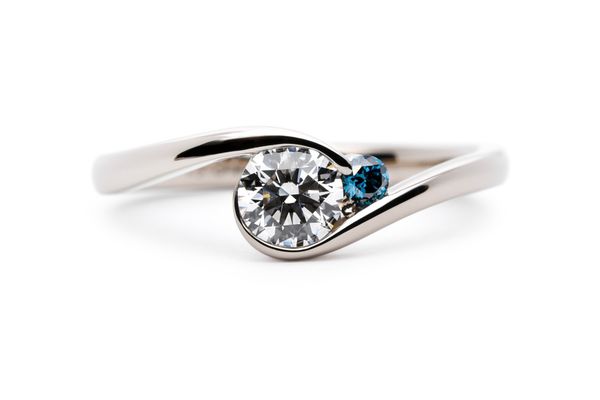 ブルーのワンサイドメレが留まった巻き込み型の手作り婚約指輪