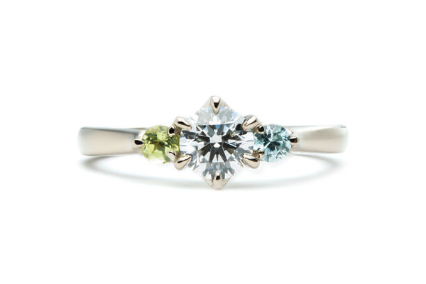 ペリドットとブルージルコンが留まったシャンパンゴールドの婚約指輪