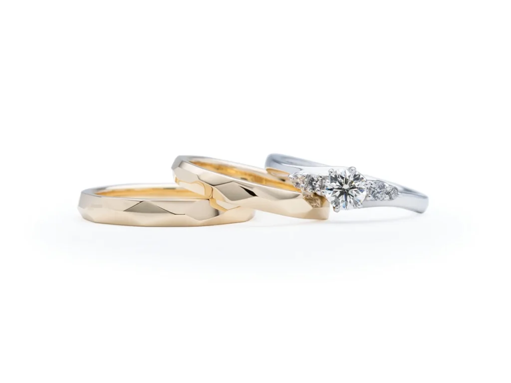 流れるようなサイドメレの婚約指輪とゴールドのファセットの手作り結婚指輪 K&M