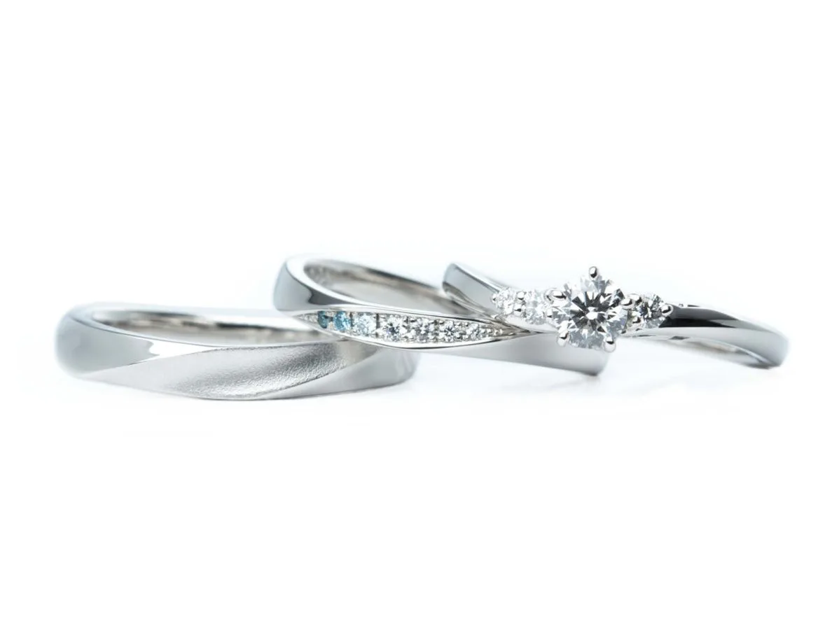 アイスブルーダイヤモンドを使用したひねりの結婚指輪とアシンメトリーデザインの婚約指輪のセットリング