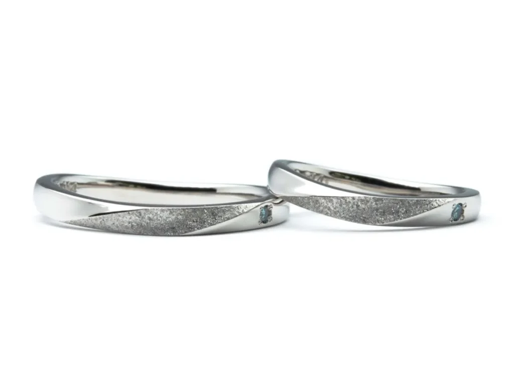 U字のふたひねりにスターダスト加工とブルーダイヤがポイントの結婚指輪