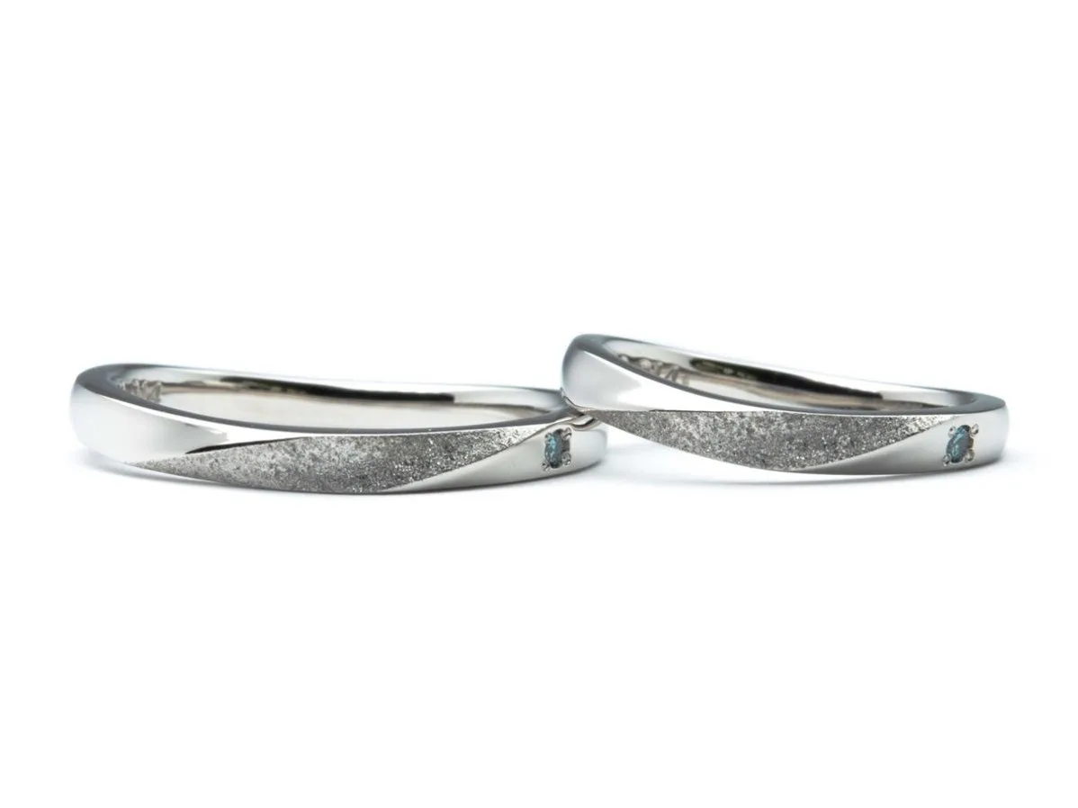 U字のふたひねりにスターダスト加工とブルーダイヤがポイントの結婚指輪
